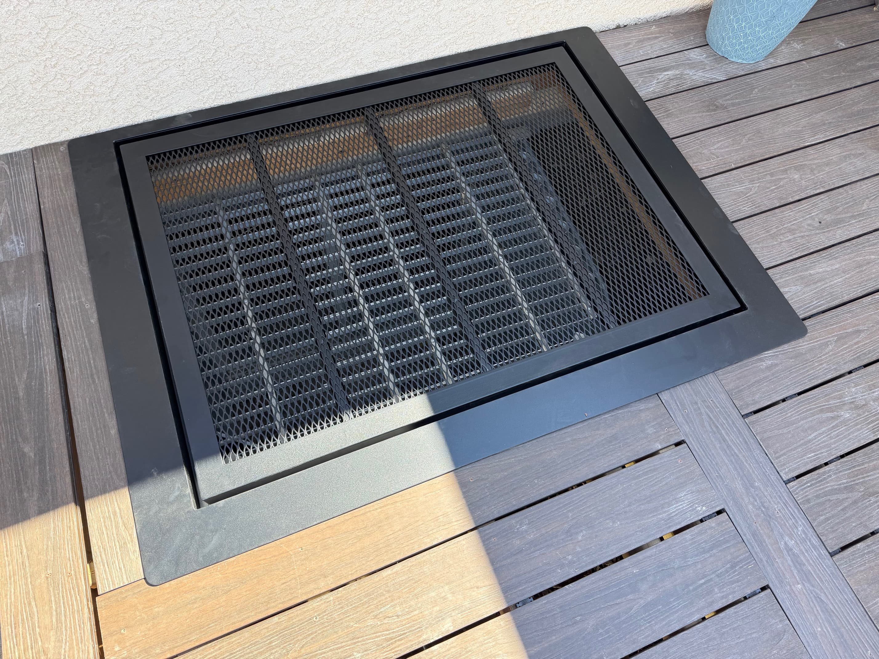 Top view of custom window well cover on wooden deck