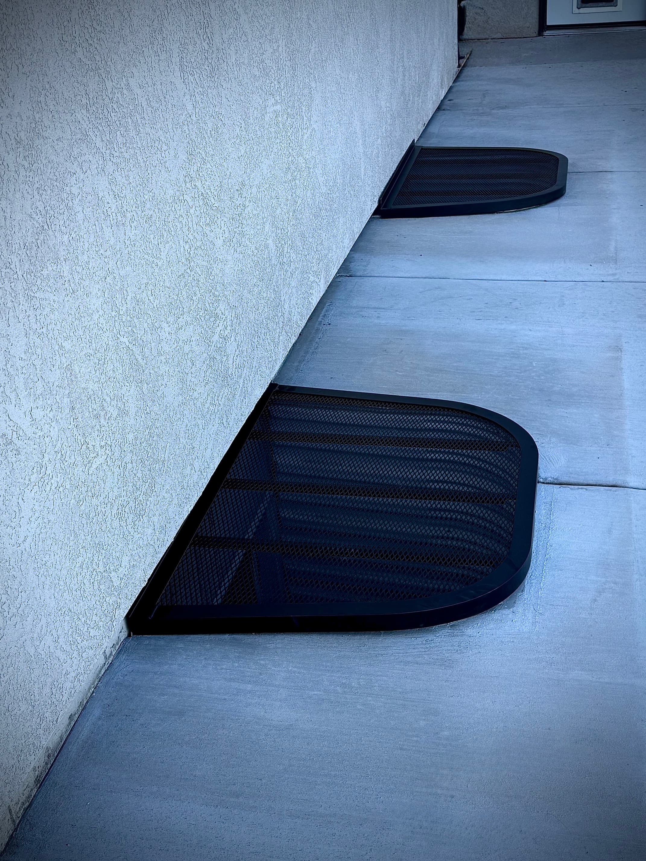 Multiple custom window well covers along walkway